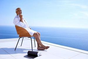 senior man in front of modern home photo