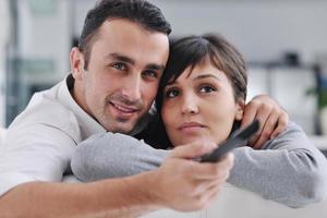 Relaxed young  couple watching tv at home photo