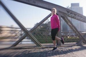 mujer estirándose antes de trotar por la mañana foto