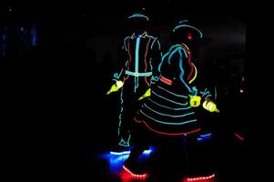 Professional barman and led light show. Silhouette of modern bartender shaking drink at night cocktail bar. photo