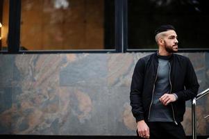 Portrait of stylish arab beard man wear grey turtleneck and black jaket. Arabian model guy. photo