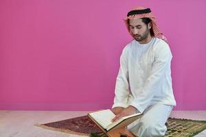 Young muslim man reading Quran during Ramadan photo