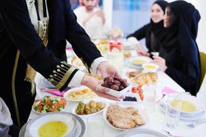 Muslim family having Iftar dinner eating dates to break feast photo
