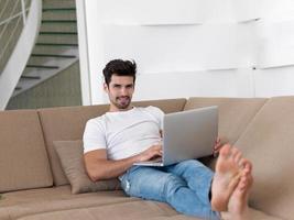 Man Relaxing On Sofa With Laptop photo