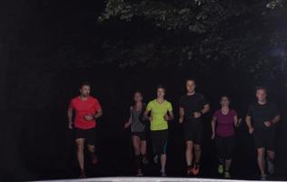 equipo de corredores en el entrenamiento nocturno foto