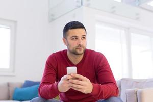 young man using a mobile phone  at home photo