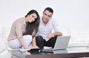 joyful couple relax and work on laptop computer at modern home photo