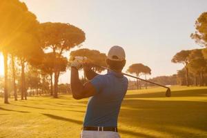 golf player hitting shot with club photo