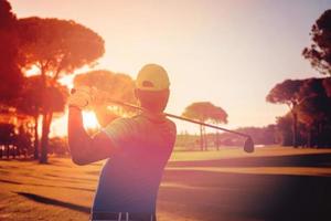 golf player hitting shot with club photo