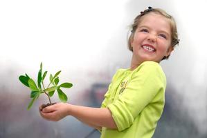 little girl holding small plant photo