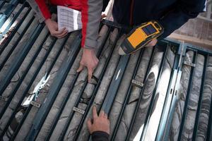 team of mining  workers measuring drilled rock core photo