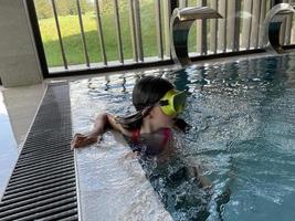 Smiling child in goggles swim, dive in the pool with fun - jump deep down underwater. Healthy lifestyle, people water sport activity on summers. photo