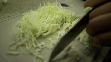 Slices slices of cabbage on a whiteboard. Grind thin slices with a sharp knife. video