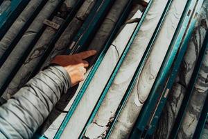 muestras de núcleos geológicos de oro con un equipo de trabajadores mineros que miden la vista superior de la roca perforada. enfoque selectivo foto