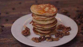 Pancakes with honey and nuts on a plate video