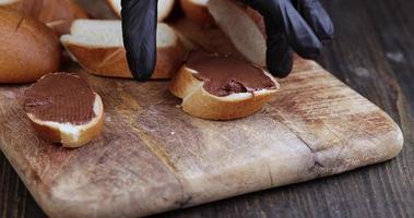 mover la baguette de mantequilla de chocolate, untar mantequilla de chocolate dulce foto