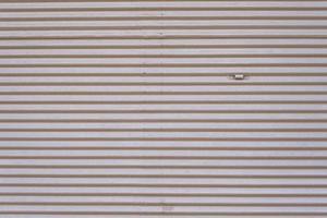 Grey vintage striped door, closeup of garage steel wall texture, horizontal lines pattern, background. photo