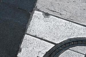 líneas blancas y oscuras de cruce en la ciudad, cierre, textura y patrón de carretera, fondo de pavimento grueso, superficie de suelo de calle texturada. foto