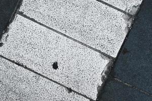 Closeup of road texture and pattern, textured street ground surface, white and dark lines of crossing in the city, grunge pavement background. photo