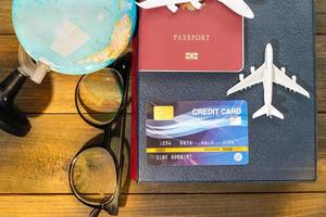 Credit card and airplane model on wooden table photo