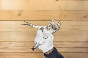 Hand in glove holding Adjustable wrench photo