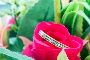 Wedding ring resting in a fake rose flower photo