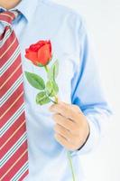 Man holding red rose in hand on white photo