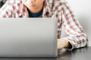 Male working with a Laptop computer on the table photo