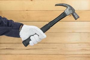 Hand in glove holding hammer photo