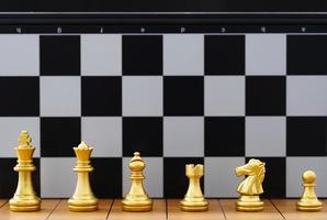 Gold set chess piece stand on wood chessboard photo