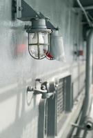 Deck lamp on ship in protective cage photo