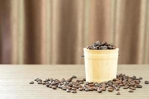 granos de café en cubo de madera foto