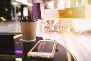 Take away coffee cup empty blank copy space for your design text or banner of brand and smartphone on the table in the cafe photo