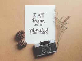 Eat drink and be married quote on paper with vintage film camera photo