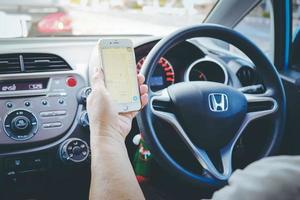 Hand holding Apple iPhone6s showing route from Google Maps in the car, Google Maps is one of the most popular GPS applications. photo