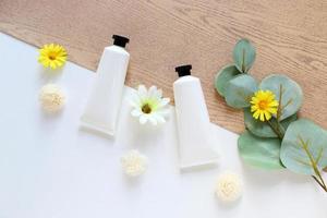 Flat lay of various organic skincare and beauty products for mock up with green leaves in minimal style photo