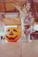 calabaza para la celebración de halloween decorada con flores en el café foto