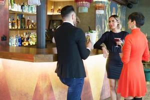 Company of elegant friends gathering in bar photo