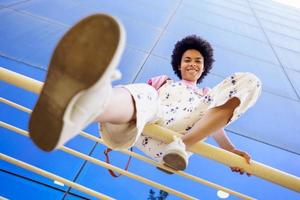 mujer negra sonriente sentada en la baranda foto