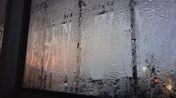 vista desde la ventana en la mañana fría con gotas de lluvia de agua sobre el vidrio foto