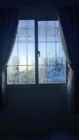 vista desde la ventana en la mañana fría con gotas de lluvia de agua sobre el vidrio foto
