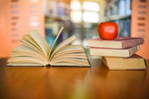 Books on the table with bookshelf in the library bookshelves background - Education learning concept open book stack photo