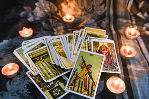 carta de tarot con luz de velas en el fondo de la oscuridad para la ilustración de magia oculta de astrología - horóscopos espirituales mágicos y concepto de adivino de lectura de palma foto