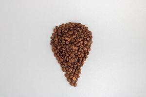 Coffee beans. Isolated on a gray background in the shape of a drop photo