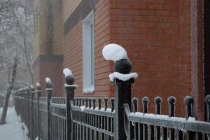 A snow cap on a wrought iron fence after a cold winter blizzard photo