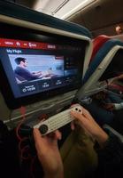 The interior of the passenger seat of a Turkish Airlines plane that has a touch screen for in-flight entertainment. Which is also equipped with a remote controller that also functions as a game stick photo