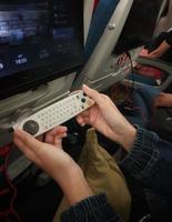 The interior of the passenger seat of a Turkish Airlines plane that has a touch screen for in-flight entertainment. Which is also equipped with a remote controller that also functions as a game stick photo