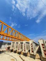 Several girders are arranged below yellow launcher gantry photo