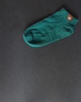 A green sock on a black background. photo