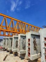 Several girders are arranged below yellow launcher gantry photo